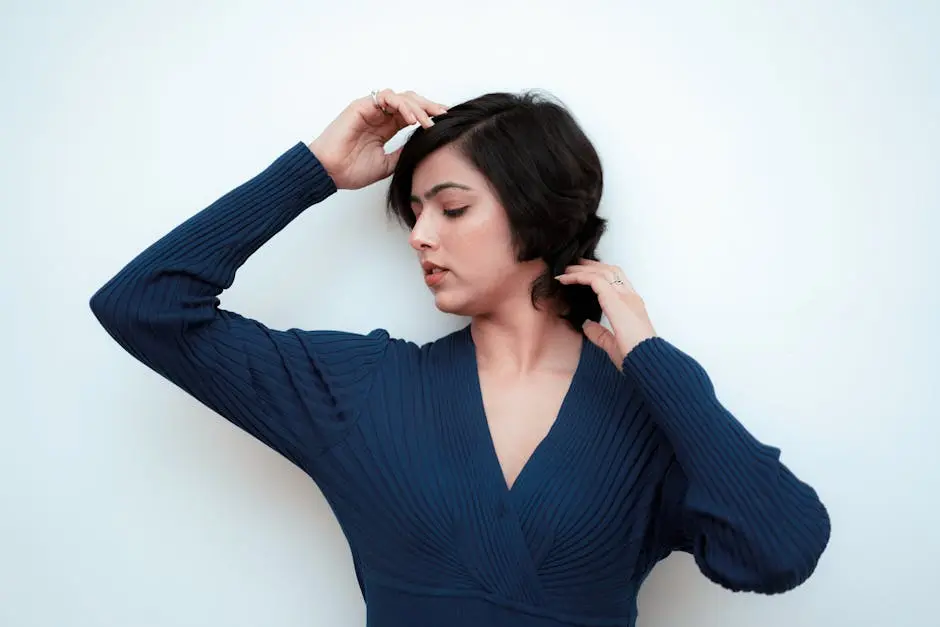 Long pixie cut: Kvinne med kort, stilig hår i mørk blå ribbet genser mot hvit bakgrunn.